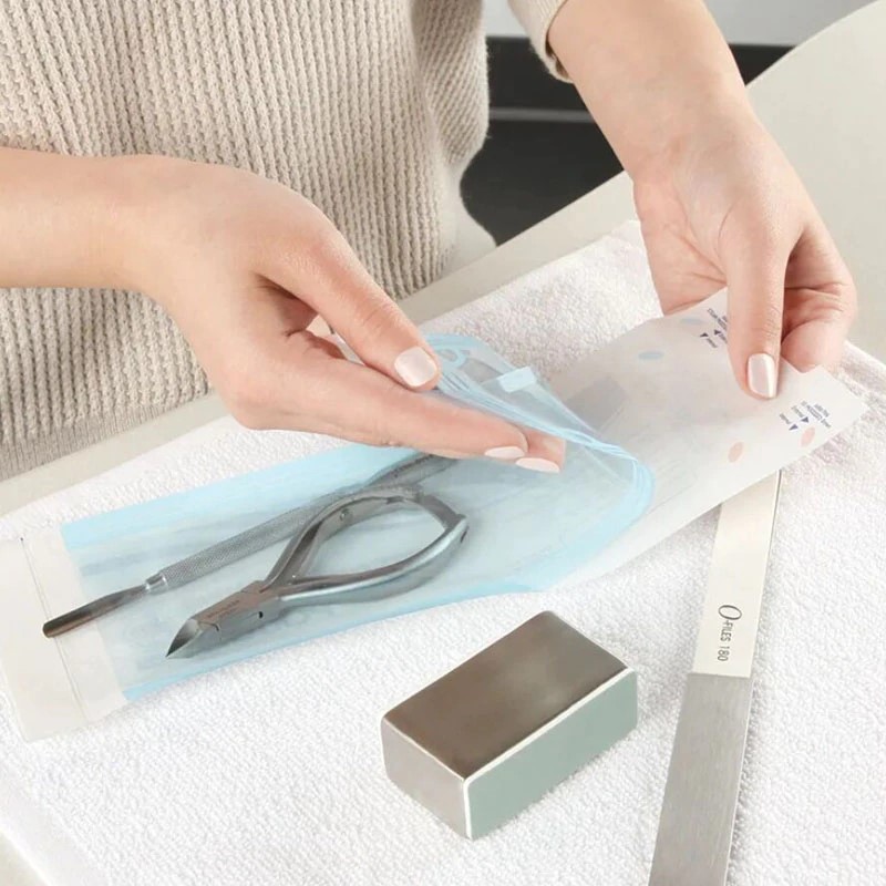 Self-sealing sterilisation pouch with colour-change indicators
